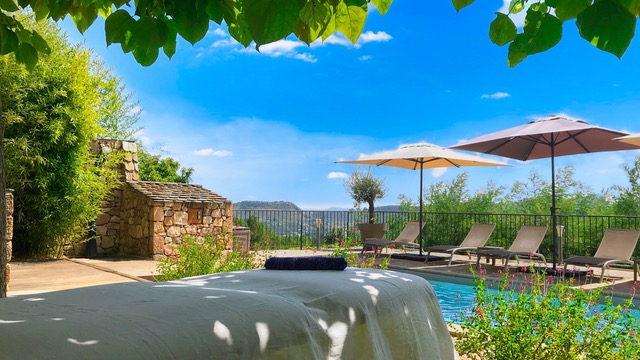 Table de massage installée en extérieur, au bord d'une piscine, dans un cadre de vacances